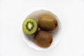 Fresh and juicy kiwi fruit, chopped and whole on a white plate. Delicious fruits and pieces of green kiwi