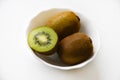 Fresh and juicy kiwi fruit, chopped and whole on a white plate. Delicious fruits and pieces of green kiwi Royalty Free Stock Photo