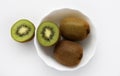 Fresh and juicy kiwi fruit, chopped and whole on a white plate. Delicious fruits and pieces of green kiwi Royalty Free Stock Photo