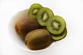 Fresh and juicy kiwi fruit, chopped and whole on a white plate. Delicious fruits and pieces of green kiwi Royalty Free Stock Photo