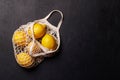 Fresh juicy lemons in a mesh bag, flat lay style Royalty Free Stock Photo