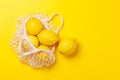 Fresh juicy lemons in a mesh bag, flat lay style Royalty Free Stock Photo