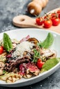 Fresh Juicy medium Rare marbled meat veal grillsteak with grilled vegetables, nuts, sauce. vertical image. top view Royalty Free Stock Photo