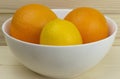 Fresh juicy natural apples and oranges in a shiny white plate on wooden background