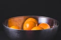 Fresh juicy oranges in a steel bowl in black background.Citrus f