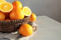 Fresh juicy oranges in wicker basket on table. Royalty Free Stock Photo