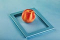 Fresh juicy peach isolated on a blue background with a blue frame Royalty Free Stock Photo