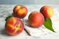 Fresh juicy peaches, leaves and fabric on table Royalty Free Stock Photo