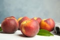 Fresh juicy peaches, leaves and fabric on white table Royalty Free Stock Photo