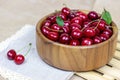 Fresh juicy red sweet cherry berries in the wooden bowl on light background in summer.