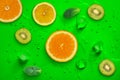 Fresh juicy slices of lemon, kiwi fruit and orange on bright green background Royalty Free Stock Photo