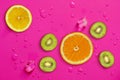 Fresh juicy slices of orange, kiwi fruit and lemon on bright red background covered with water drops Royalty Free Stock Photo