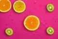 Fresh juicy slices of orange, kiwi fruit and lemon on bright red background covered with water drops Royalty Free Stock Photo