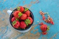 fresh juicy strawberries in an enamel mug on an old wooden rural table, next to it is a currant berries Royalty Free Stock Photo