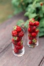 Fresh juicy strawberries in a glass on a wooden table in the garden. Natural Strawberry Juice Concept Royalty Free Stock Photo