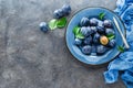 Fresh juicy sweet plums on plate with leaves Royalty Free Stock Photo