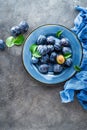 Fresh juicy sweet plums on plate with leaves Royalty Free Stock Photo