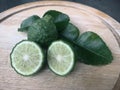 Fresh kaffir lime and sliced on wood cutting board. The oily substance extracted from the peel of the bergamot fruit is used in Royalty Free Stock Photo