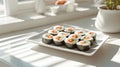 Fresh kimbap rolls with colorful vegetables on white rectangular plate in bright minimalist kitchen with natural Royalty Free Stock Photo