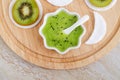 Fresh kiwi fruit puree in a small white bowl, cotton eye patch. Homemade face or eye mask, natural beauty treatment and spa recipe