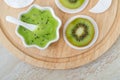 Fresh kiwi fruit puree in a small white bowl and cotton pads. Homemade face or eye mask, natural beauty treatment and spa recipe.