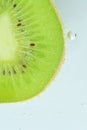 Fresh kiwi fruit slice in liquid with bubbles. Close-up of a kiwi fruit slice in soda water. Bubbles on kiwi fruit Royalty Free Stock Photo