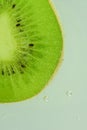 Fresh kiwi fruit slice in liquid with bubbles. Close-up of a kiwi fruit slice in soda water. Bubbles on kiwi fruit Royalty Free Stock Photo