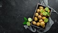 Fresh kiwi and green leaves in a wooden box on the old background. Fruits. Royalty Free Stock Photo