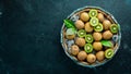 Fresh kiwi and green leaves in a wooden box on the old background. Fruits. Top view. Royalty Free Stock Photo