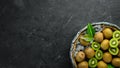 Fresh kiwi and green leaves in a wooden box on the old background. Fruits. Top view. Royalty Free Stock Photo