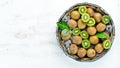 Fresh kiwi and green leaves in a wooden box on the old background. Fruits. Top view. Royalty Free Stock Photo