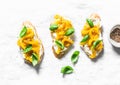 Fresh labne and baked sweet pepper bruschetta on a light background, top view. Tasty tapas