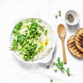 Fresh labne with green peas, olive oil and spices. Healthy diet breakfast, snack, appetizer on a light background