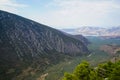 Fresh landscape view of Parnassus mountain slope valley, green olive groves through Ionian sea with bright sky background