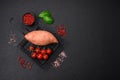 Fresh large pink sweet potato tubers with tomatoes and spices on a dark background Royalty Free Stock Photo