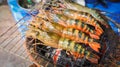 Fresh large river prawn grilled on flaming grill using charcoal stove Royalty Free Stock Photo