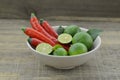 Fresh lemon cut half with chili in bowl on wooden background Royalty Free Stock Photo