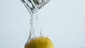 Fresh lemon dropping water in light background closeup. Organic tropical fruit