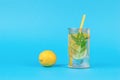 Fresh lemon and a glass of water with mint and lemon on a blue background Royalty Free Stock Photo