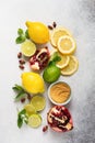 Fresh lemon, lime, pomegranate, dried tea rose flowers, tea, cane sugar, mint leaves and glass teapot on gray background. Ingredie Royalty Free Stock Photo