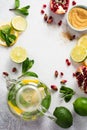 Fresh lemon, lime, pomegranate, dried tea rose flowers, tea, cane sugar, mint leaves and glass teapot on gray background. Royalty Free Stock Photo