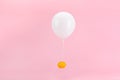 Fresh lemon tied to a white balloon on a pink background