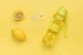 Fresh lemon, water bottle and wireless headphones on a yellow background Royalty Free Stock Photo