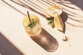 Fresh lemonade with mint leaves and ice cubes on yellow background, sharp shadows, top view Royalty Free Stock Photo