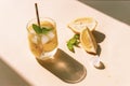 Fresh lemonade with mint leaves and ice cubes on yellow background, sharp shadows, top view Royalty Free Stock Photo