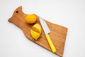 Fresh lemons a cutting board.A half of a yellow lemon on a wooden chopping board with a knife.Composition of delicious Royalty Free Stock Photo