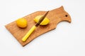 Fresh lemons a cutting board.A half of a yellow lemon on a wooden chopping board with a knife.Composition of delicious Royalty Free Stock Photo