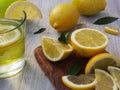 Fresh lemons on a cutting board placed on a wooden table. In the foreground one lemon cut in half. Royalty Free Stock Photo