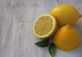 Fresh lemons on a cutting board placed on a wooden table. In the foreground one lemon cut in half. Royalty Free Stock Photo