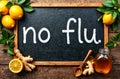 Fresh lemons, ginger root, and honey are arranged around a chalkboard with a message emphasizing flu prevention Royalty Free Stock Photo